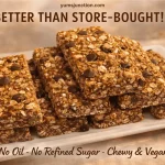 A stack of thick, rectangular granola bars filled with rolled oats and dark chocolate chips on a white rectangular plate. The image has a warm, golden tone. Text at the top reads "yumsjunction.com" and "BETTER THAN STORE-BOUGHT!" Text at the bottom says "No Oil - No Refined Sugar - Chewy & Vegan."