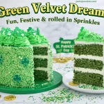 A promotional graphic for a "Green Velvet Dream!" cake. It shows the sprinkle-covered St. Patrick's Day cake with a slice cut out, revealing three layers of dark green velvet cake with white cream cheese frosting. A large slice sits on a white plate beside the main cake. The scene is decorated with gold chocolate coins and loose sprinkles on a white marble surface, with a small "Happy St. Patrick's Day" sign in the background. Bold text at the top reads "Green Velvet Dream!" and "Fun, Festive & rolled in Sprinkles."