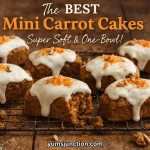 A horizontal food graphic titled "The BEST Mini Carrot Cakes" in bold orange text. Below the title, white script reads "Super Soft & One-Bowl!" The central image shows six mini carrot cakes on a black wire cooling rack over a dark wooden surface. The cakes feature thick white frosting dripping down the sides and are topped with walnuts and shredded carrots. One cake in the foreground has a bite taken out of it. The Yum Junction logo and website address are visible at the top left and bottom center.