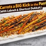 A horizontal promotional graphic with a dark brown angled banner at the top. The banner contains bold yellow and orange text that reads "Give Carrots a BIG Kick in the Pants! (With Labneh & Shortcut Dukkah)." The main image shows the finished carrot dish on a marble surface. Includes the Yum Junction logo and the website URL yumsjunction.com at the bottom.