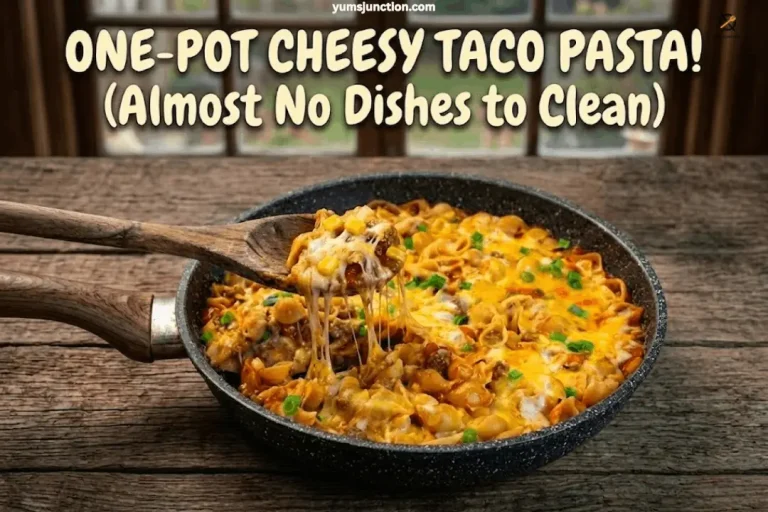 Overhead shot of one-pot cheesy taco pasta in a skillet with a wooden spoon lifting a cheesy bite