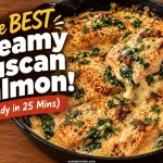 Spatula lifting a creamy Tuscan salmon fillet with spinach and sun-dried tomatoes from a cast iron skillet